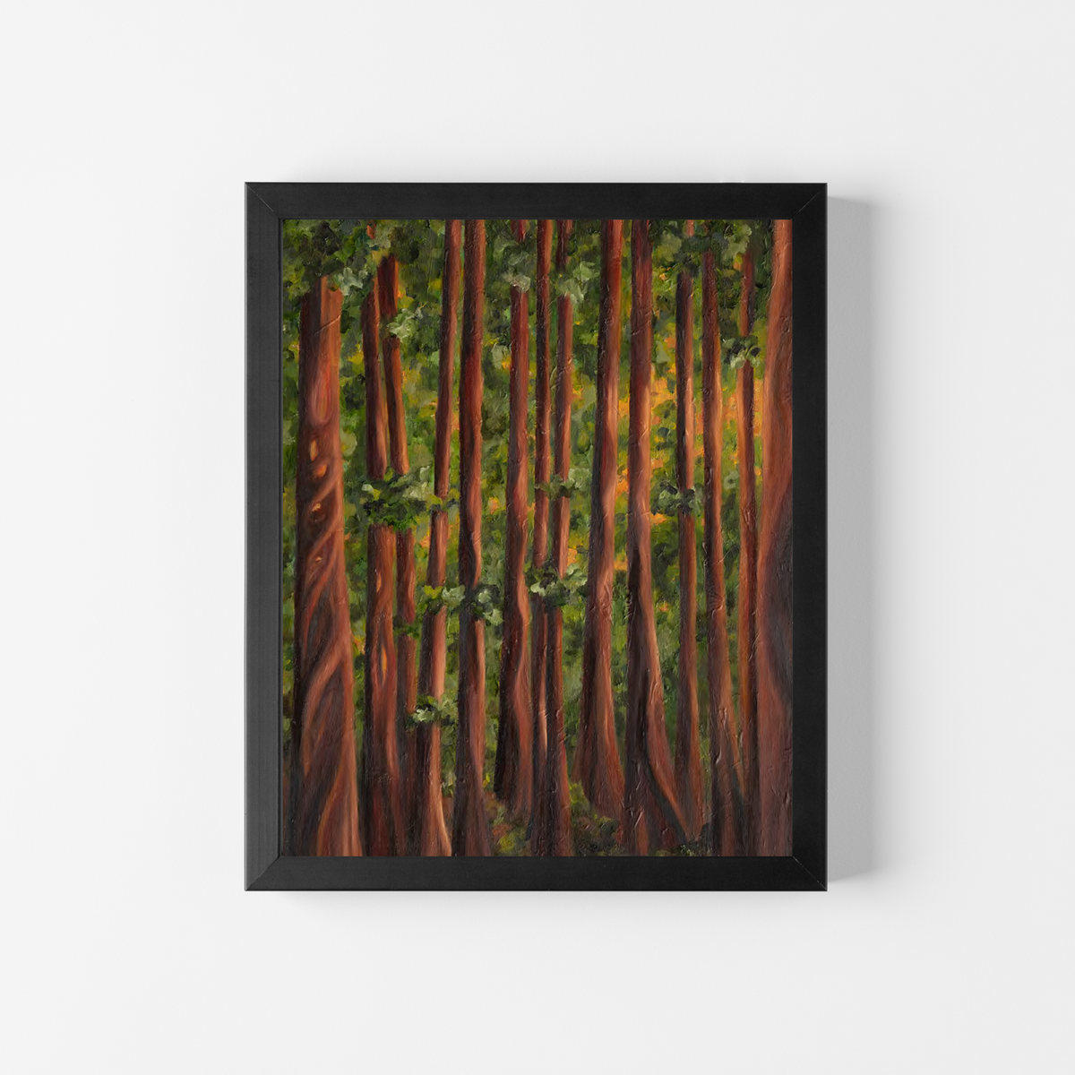 A framed vertical art print depicting a dense forest of tall redwood trees with warm brown trunks and green foliage, mounted on a clean white wall.