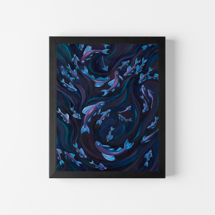 A framed vertical art print featuring a swirling dark blue and black background with numerous small light blue and purple fish, displayed on a clean white wall.